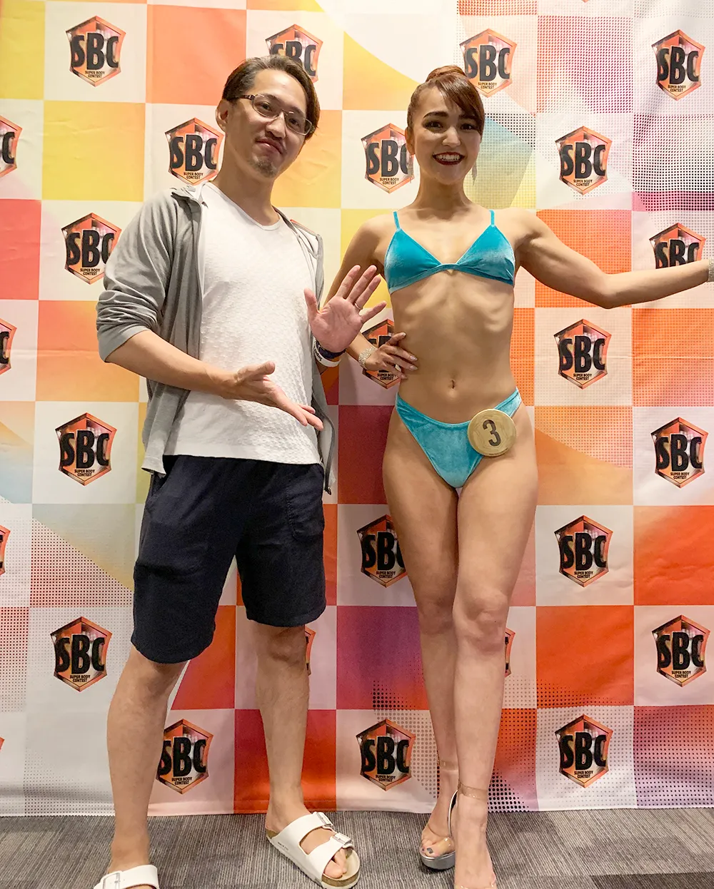水着姿の女性と並ぶ杉田代表